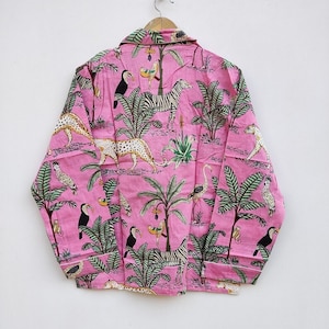 Puede incluir: Camisa de pijama rosa con estampado de animales tropicales con cebras, leopardos, tucanes y palmeras. La camisa de manga larga tiene ribetes blancos y cierre de botones. La tela es ligera y suave.