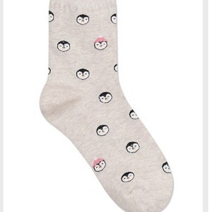May include: A pair of grey socks with a penguin pattern. The penguins are wearing pink hats.