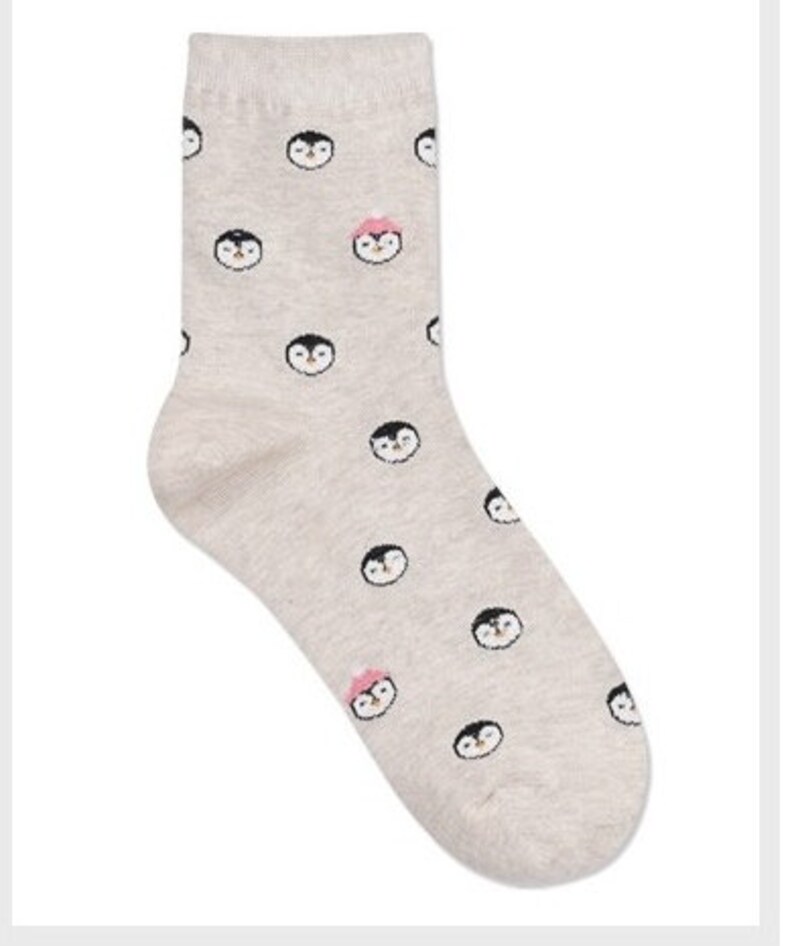 May include: A pair of grey socks with a penguin pattern. The penguins are wearing pink hats.