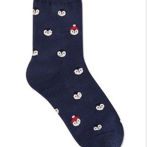 May include: A pair of dark blue socks with a pattern of penguins wearing red hats.