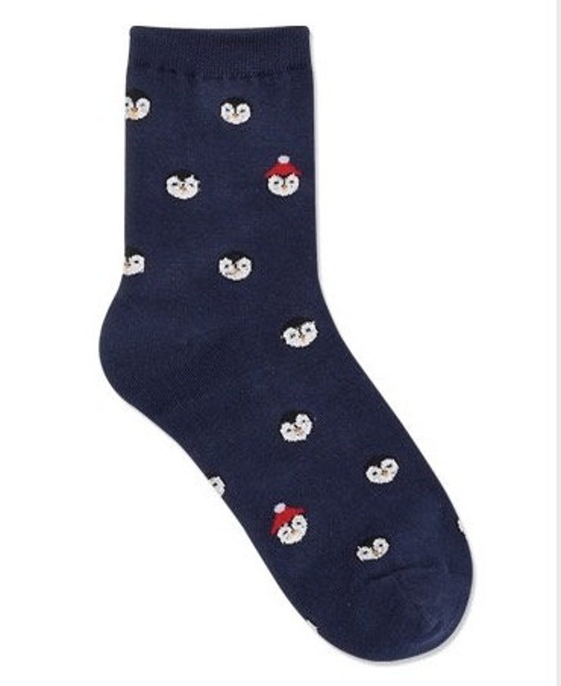 May include: A pair of dark blue socks with a pattern of penguins wearing red hats.