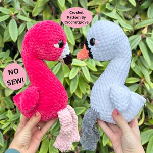 Puede incluir: Un juguete de peluche amigurumi de crochet en forma de flamenco rosa y cisne blanco. Ambos juguetes tienen ojos negros y mantienen la cabeza erguida. El flamenco tiene patas rosas y el cisne tiene patas grises. Los juguetes están sostenidos en las manos de una persona. El fondo es un arbusto verde frondoso. El texto "NO SEW!" está en un círculo rosa en la esquina inferior izquierda de la imagen.