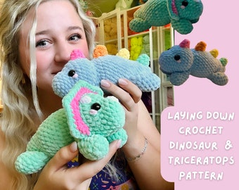 May include: A crochet pattern for a laying down dinosaur and triceratops. The pattern is shown with a blue dinosaur and a green triceratops. The pattern is available for purchase on Etsy.