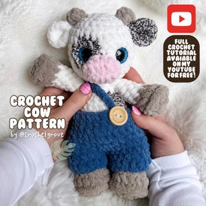 May include: Crocheted cow amigurumi toy with black and white spots, blue overalls, and a pink nose. The toy is being held by a person's hands. The text "CROCHET COW PATTERN by @crochetgrove" is visible at the bottom of the image.