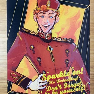 May include: A rectangular art print featuring a stylized illustration of a person in a red bellhop uniform with gold accents and a matching cap. The text reads: Sparkle on! It's Wednesday! Don't Forget to be yourself! The background is yellow and black.