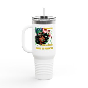 May include: White travel mug with a handle and a straw. The mug features a graphic of a woman wearing a green leprechaun hat and an American flag. Text on the mug reads "America 250" and "Happy St. Paddy's!!!"