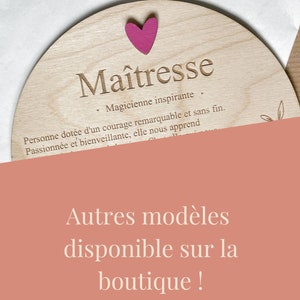 Pu&ograve; includere: Una targa in legno con la parola "Ma&icirc;tresse" incisa su di essa. La targa &egrave; decorata con un cuore rosa e un piccolo disegno floreale. Il testo sotto la parola "Ma&icirc;tresse" recita: "Magicienne inspirante. Personne dot&eacute;e d'un courage remarquable et sans fin. Passionn&eacute;e et bienveillante, elle nous apprend."