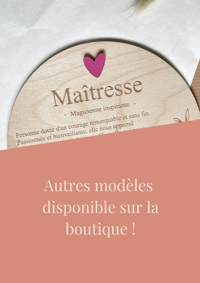 Pu&ograve; includere: Una targa in legno con la parola "Ma&icirc;tresse" incisa su di essa. La targa &egrave; decorata con un cuore rosa e un piccolo disegno floreale. Il testo sotto la parola "Ma&icirc;tresse" recita: "Magicienne inspirante. Personne dot&eacute;e d'un courage remarquable et sans fin. Passionn&eacute;e et bienveillante, elle nous apprend."