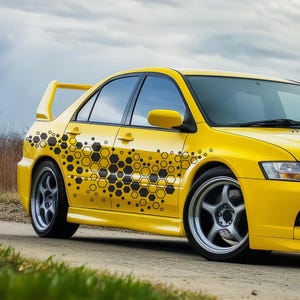 May include: A yellow car with a black honeycomb pattern decal on the side. The car has a black front bumper and black wheels.