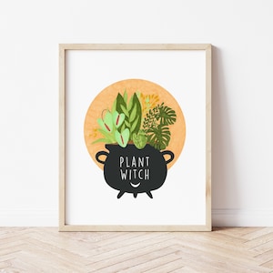 May include: A black cauldron with a smiling face filled with green plants and the text "PLANT WITCH" on a white background with a peach-colored circle behind the cauldron.