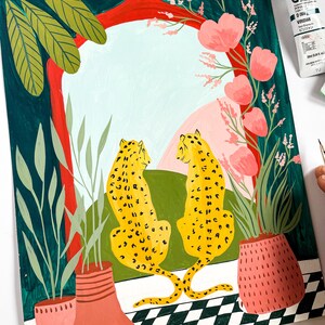 May include: A painting of two yellow leopards with black spots sitting in front of a red and green archway. The archway is framed by pink flowers and green leaves. The leopards are facing each other and have their tails intertwined. The background is a light blue sky with pink clouds.