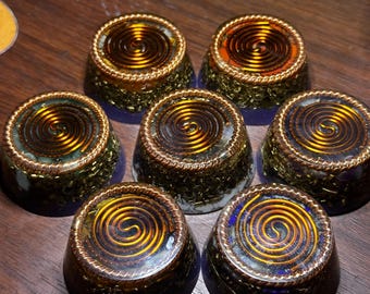 May include: Seven circular resin ornaments arranged in a cluster. Each piece features a clear, smooth top surface embedded with a coiled copper wire spiral and a base filled with metallic gold-toned shavings and various small, colorful stone fragments.