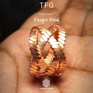 May include: A copper finger ring with a braided design. The ring is made of multiple strands of copper wire that are woven together to create a unique and intricate pattern. The ring is a beautiful and unique piece of jewellery that would make a great gift for someone special.