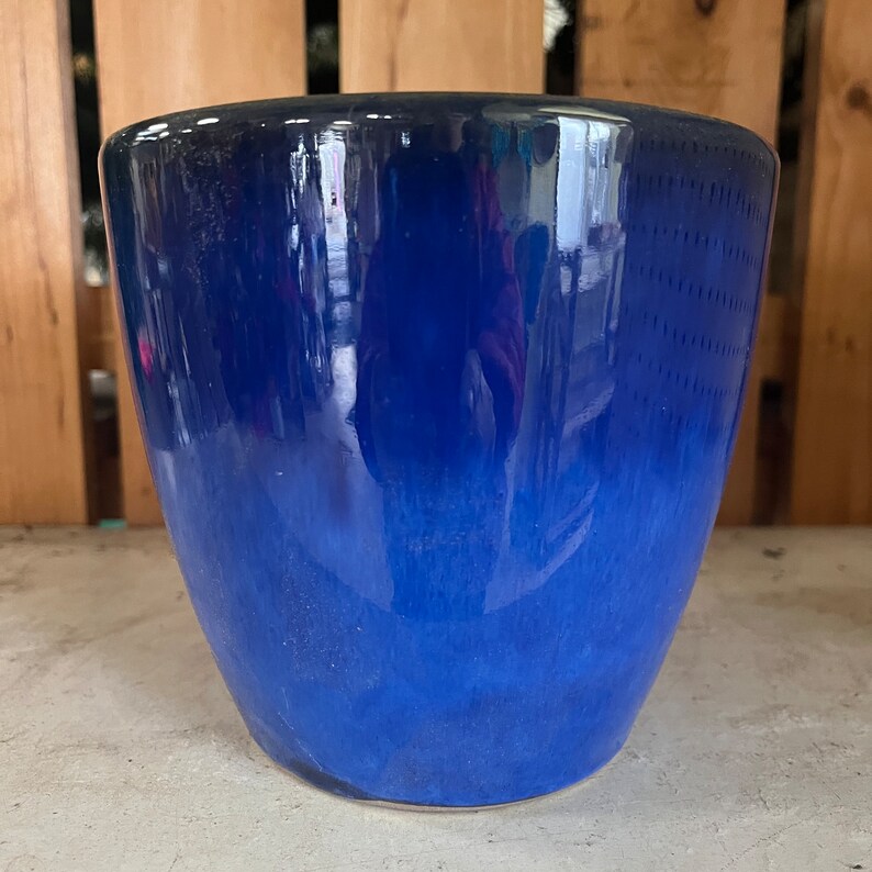 Op de afbeelding: Een blauwe keramische plantenpot met een verloop van donkerblauw naar lichtblauw. De pot is geglazuurd en heeft een gladde, glanzende afwerking.