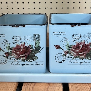 May include: Two light blue ceramic planters with a vintage postcard design featuring a rose, a stamp, and the text "READ HOUSE, Chattanooga, Tenn. 81 Langham Road".
