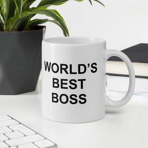 Op de afbeelding: Een witte keramische koffiemok met zwarte tekst die "WORLD'S BEST BOSS" luidt.