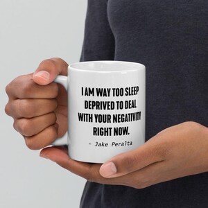 May include: White ceramic mug with a black quote that reads "I am way too sleep deprived to deal with your negativity right now. - Jake Peralta"