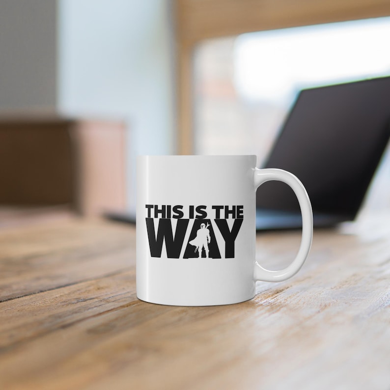 May include: White ceramic mug with a black graphic that says "This is the Way" with a silhouette of a person in the middle of the word "Way".