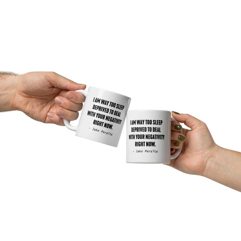 May include: Two white coffee mugs with black text. The text on the mugs reads "I am way too sleep deprived to deal with your negativity right now. - Jake Peralta".