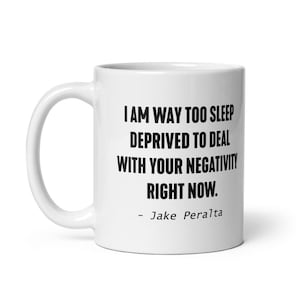 May include: White ceramic coffee mug with black text that reads "I am way too sleep deprived to deal with your negativity right now. - Jake Peralta"