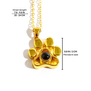 May include: Gold-colored paw print pendant necklace with a black center stone. The pendant measures 0.8 inches (2 cm). The chain length is 7.8 to 9.8 inches (20 to 24 cm).
