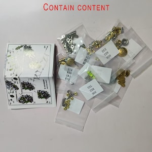 May include: A selection of small metal model kit components, such as screws and pins, presented in clear plastic bags. A folded instruction sheet is visible, with the text "CONTAIN CONTENT".