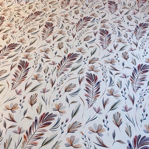 May include: A white fabric with a repeating pattern of stylized floral and leaf designs in shades of pink, brown, and gray.