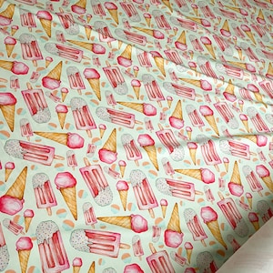 May include: A white fabric with a repeating pattern of pink and white ice cream cones and popsicles. The background is a light green color.