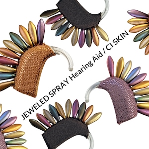 Puede incluir: Tres audífonos diferentes con cubiertas enjoyadas. Las cubiertas están hechas de cuentas iridiscentes en tonos de morado, verde, dorado y marrón. El texto "JEWELED SPRAY HEARING AID/CI SKIN" es visible en la imagen.