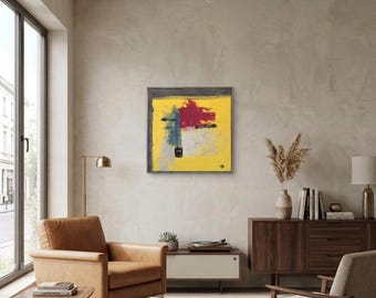 May include: Abstract painting with a yellow background, featuring red, blue, and black brushstrokes. The artwork is framed in a dark gray wooden frame and hangs on a neutral-colored wall. The painting adds a modern touch to the room.