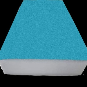 May include: A turquoise blue cushion with a white foam base. The cushion is rectangular and has a soft, plush texture.