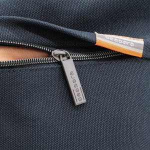 May include: Close-up of a black zipper with a silver zipper pull. The zipper pull has the word "seasara" printed on it.