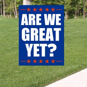 May include: A blue and red yard sign with white text that reads "Are We Great Yet?" with a row of red stars above and below the text.