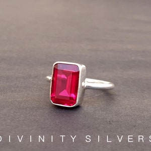 Peut inclure: Une bague en argent avec une grande pierre pr&eacute;cieuse rectangulaire rose vif.