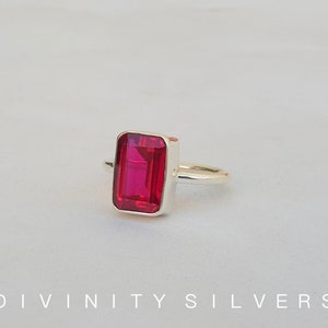 Peut inclure: Une bague en argent avec une grande pierre pr&eacute;cieuse rectangulaire rouge vif.