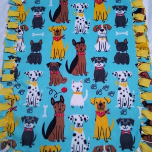 May include: A turquoise blue fleece tie blanket with a yellow fringe border. The blanket features a repeating pattern of various dog breeds wearing bandanas and collars.