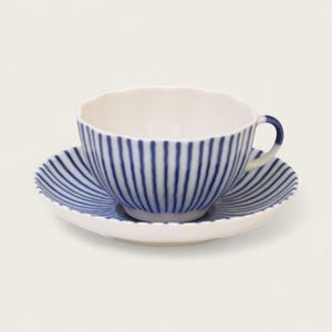 May include: A white teacup and saucer set with a blue striped pattern. The teacup has a rounded shape with a handle, and the saucer is circular. The blue stripes are vertical on the cup and radiate outward on the saucer.