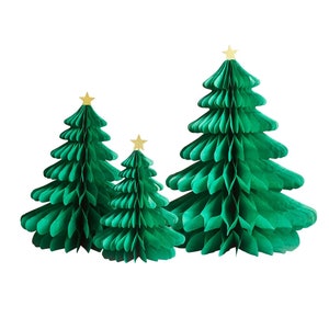 May include: Three green paper Christmas trees with gold star toppers. The trees are different sizes and are arranged in a row.