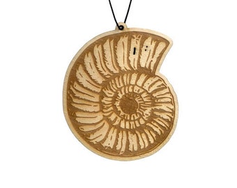 May include: A wooden ornament shaped like an ammonite, a type of extinct marine mollusk. The ornament is brown and has a detailed carving of the ammonite's spiral shell.