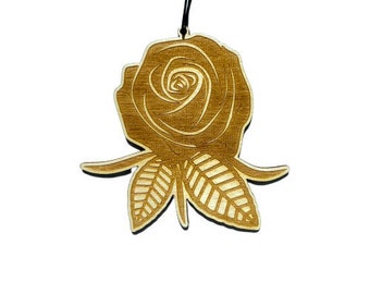 May include: A wooden rose ornament with a brown finish. The rose is detailed with a swirl pattern and has leaves.
