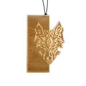 May include: A wooden ornament featuring a detailed wolf head design. The wolf's face is partially hidden behind a rectangular wooden panel. The ornament is suspended by a black string.