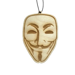 May include: A wooden cutout of the iconic Anonymous mask, featuring a stylized face with a wide smile and a prominent nose. The mask is a popular symbol of online anonymity and digital activism.