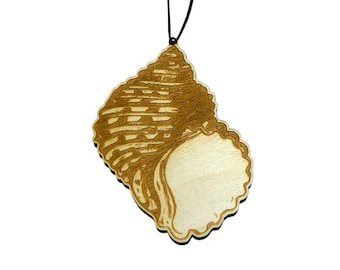 May include: A wooden seashell ornament with a detailed engraved design. The ornament is attached to a black cord, making it ready to hang.
