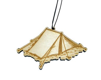 May include: A wooden tent ornament with a string for hanging. The ornament is light brown and has a detailed design of a tent.