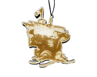 May include: A wooden ornament shaped like a ship with a sail. The ornament is brown and has a string for hanging.