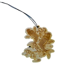 May include: A wooden car air freshener with a design of two koi fish swimming in a wave pattern.