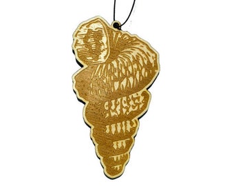May include: A wooden ornament shaped like a seashell with a detailed, intricate design. The ornament is hanging from a black string.