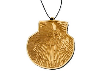 May include: A wooden shell-shaped ornament with a detailed design, hanging from a black string.