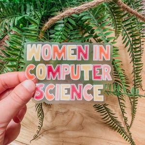May include: A clear sticker with the text "Women in Computer Science" in colorful, outlined letters. The letters are in shades of pink, red, orange, and yellow.