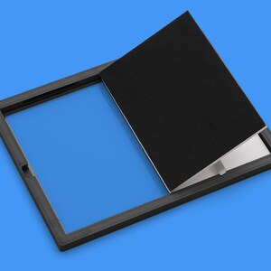 Peut inclure: Un panneau d'acc&egrave;s encadr&eacute; noir avec un couvercle noir &agrave; charni&egrave;res. Le couvercle est ouvert, r&eacute;v&eacute;lant un fond bleu.